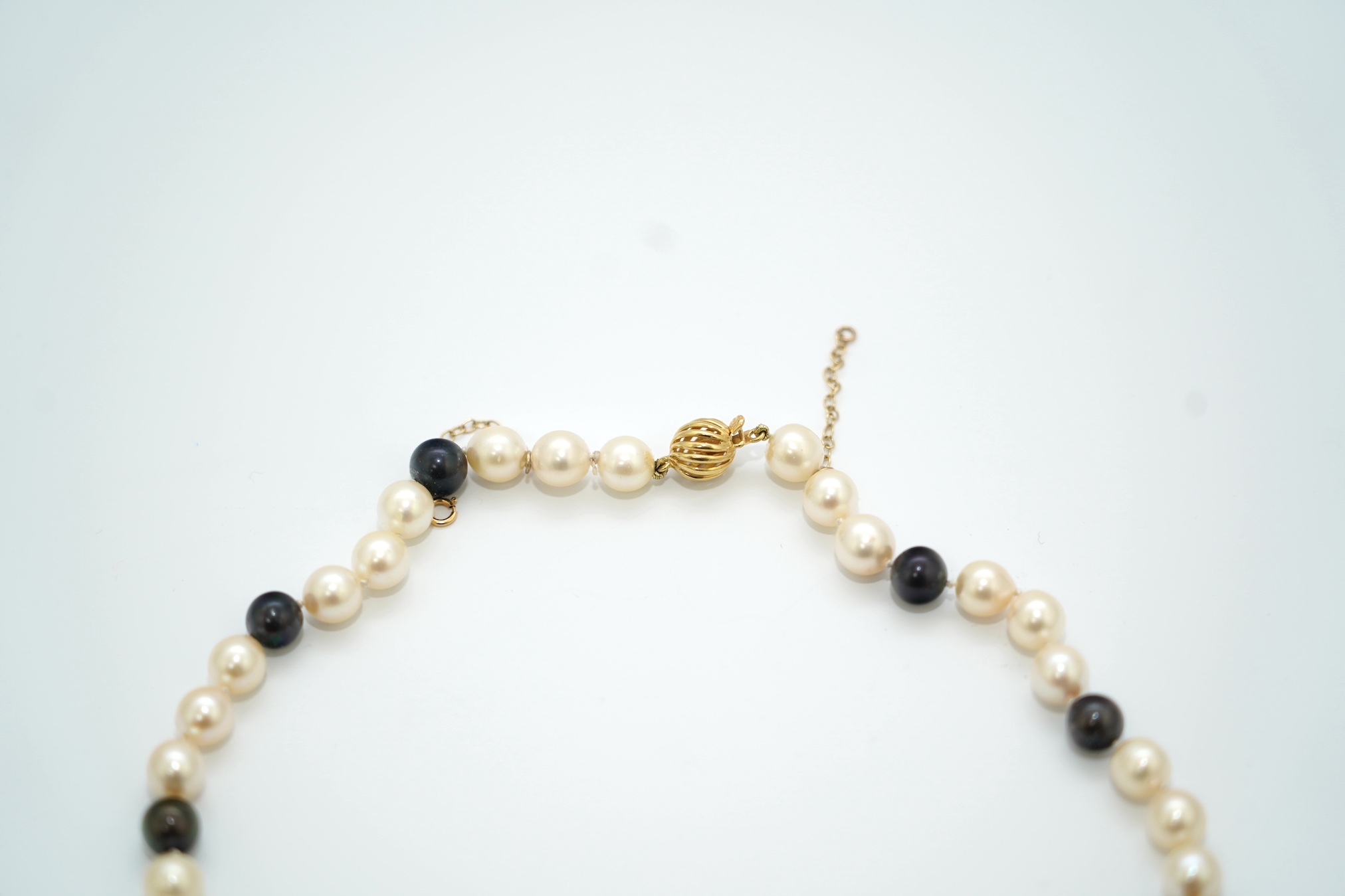 A modern single strand two colour cultured pearl necklace, with 750 yellow metal clasp, 58cm. Condition - fair